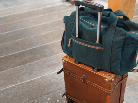 写真:向島産の帆布を使った紺のバックと茶色のスーツケース