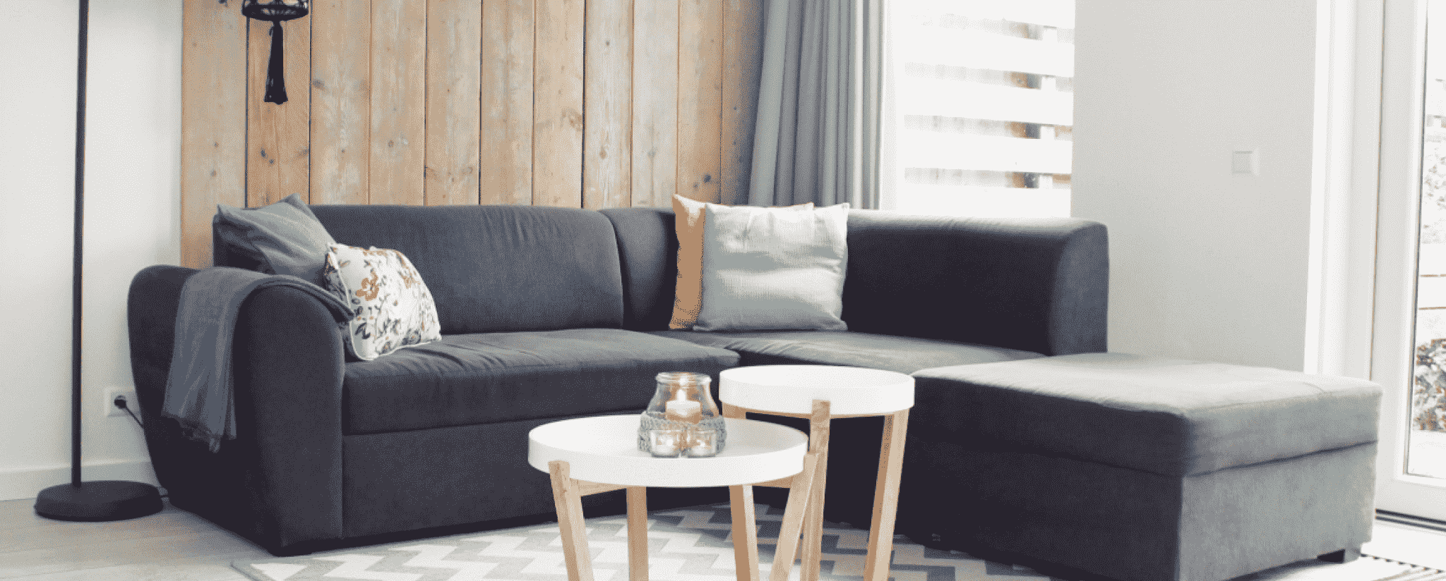 画像：グレーの大きなソファーと白を基調とした角ばった机があります