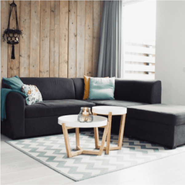 画像：グレーの大きなソファーと白を基調とした角ばった机があります